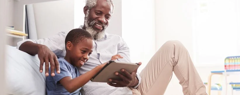 Grandfather with his grandson looking at a tablet