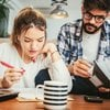 Couple helping each other fill out their taxes