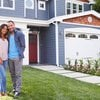 Young couple standing in front of blue house