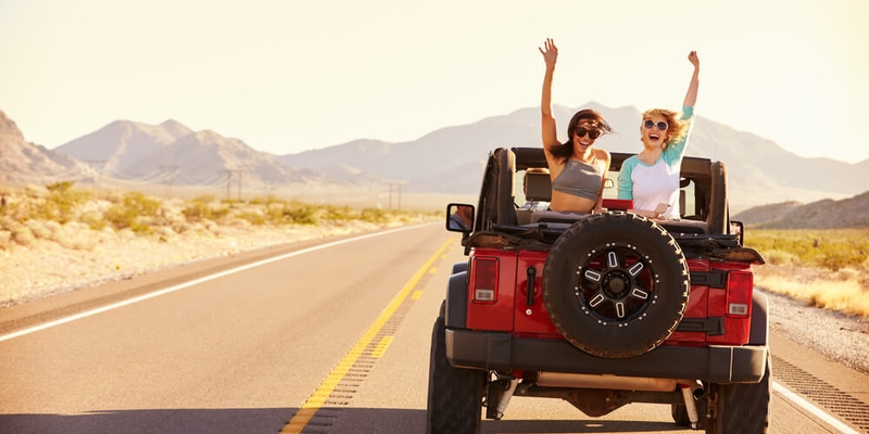 Friends On Road Trip Driving In Convertible Car.jpg