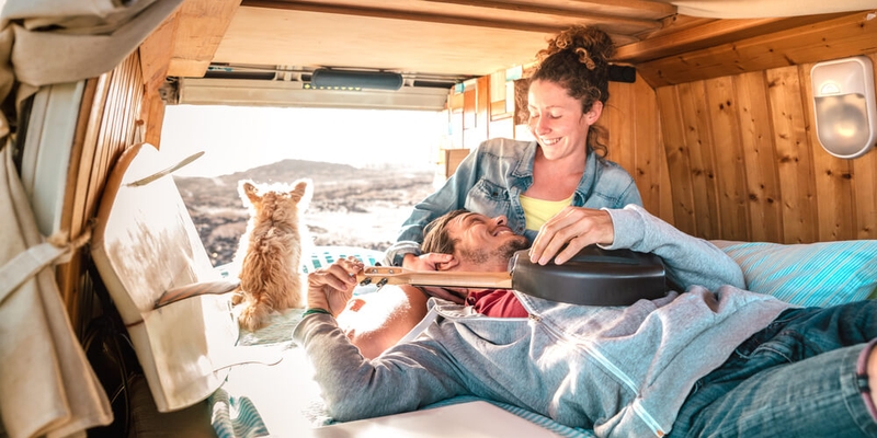 Hippie couple amd dog traveling together on vintage van transport at sunset (1)