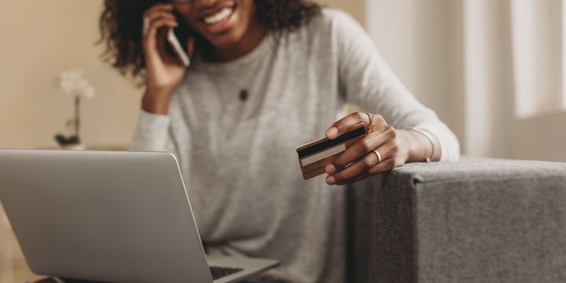 A woman gives her credit card info to someone over the phone