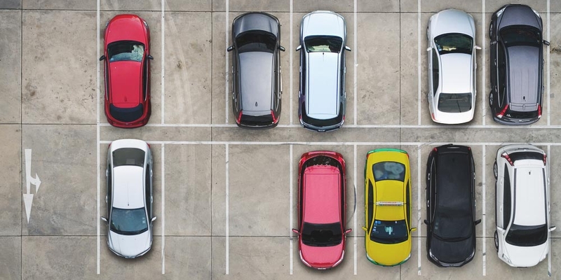 An aerial view of brightly coloured cars in a parking lot