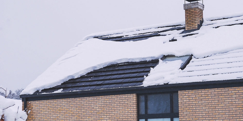 roof with snow on the shingles in the winter
