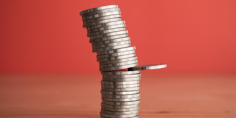 Stack coins in uncertainty situation on wooden table red background copy space (1)