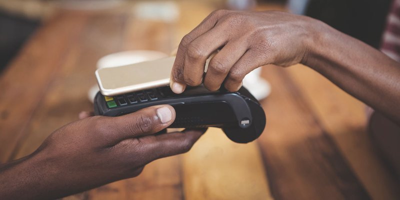 A customer uses their smartphone to pay with their mobile wallet