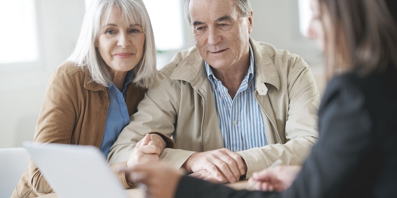 An older couple sit with a financial advisor