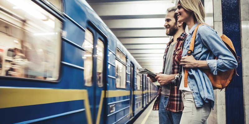 A young couple wait to board a train