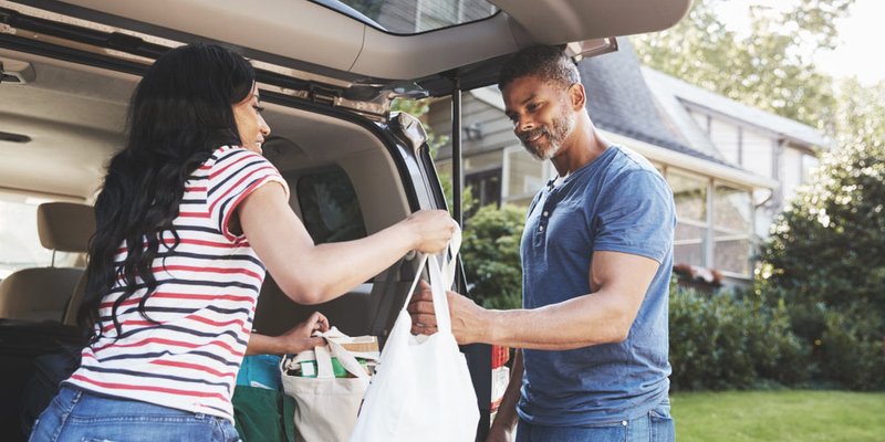 Two people taking the groceries in from the car