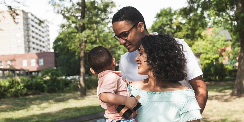 Young family with baby son walk downtown on nice sunny day