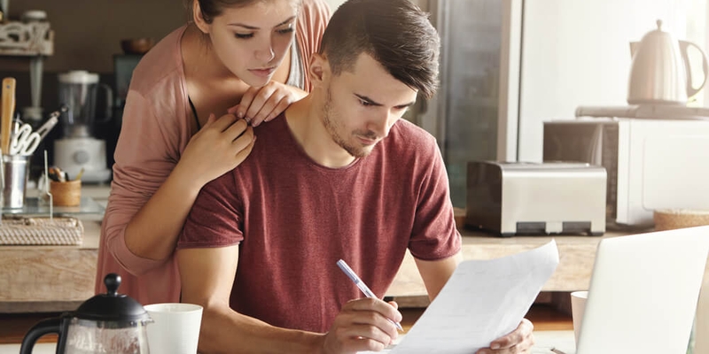 young couple distressed looking at bills_paying your mortgage after a job loss